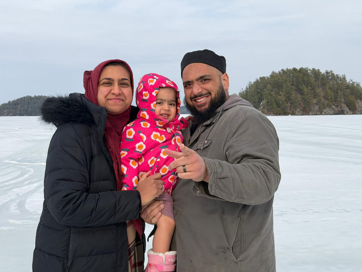 A Muslim family outdoors on a frozen lake in winter sunlight